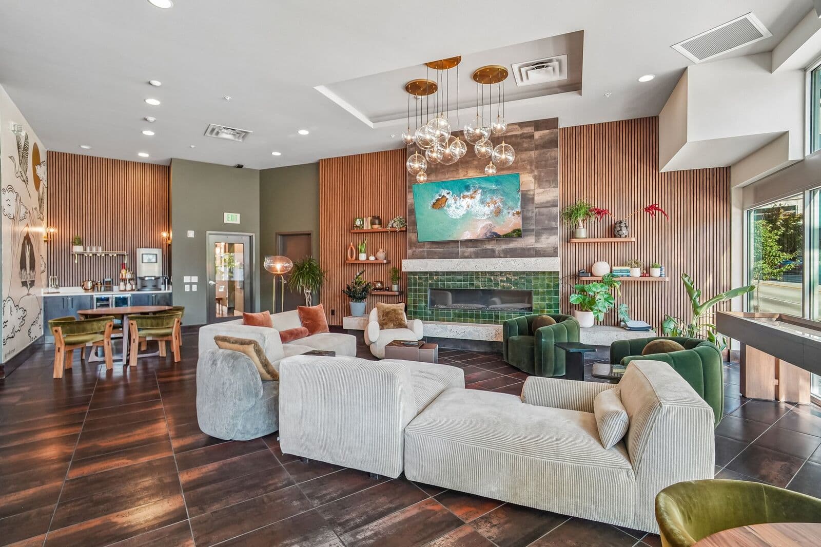The resident lounge, with a green tile fireplace, wood-slat walls and deep seating